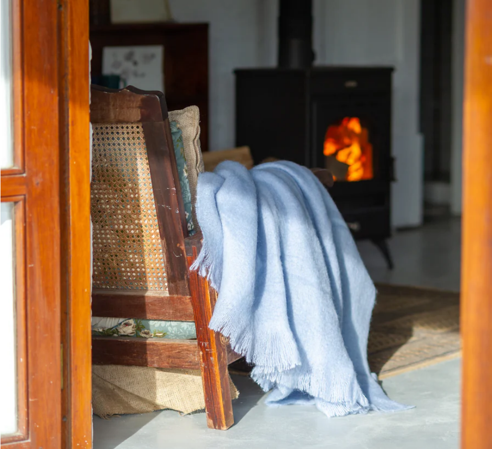 Light blue mohair wool blanket draped on a chair
